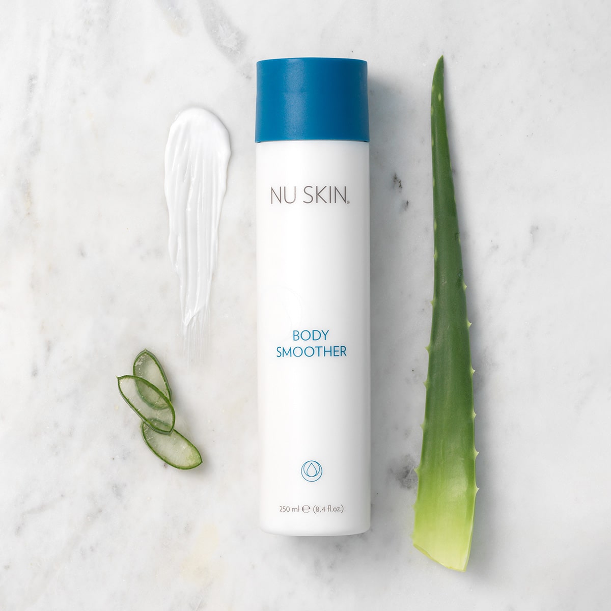 Body Smoother (Bodylotion von Nu Skin) liegt geschlossen auf marmornen Oberfläche. Daneben eine Probe der weißen Lotion und Blätter der Aloe Vera Pflanze.