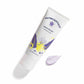 Nutricentials Brighter Day Exfoliant Scrub Tube (100ml) liegt geschlossen auf glatter Oberfläche. Daneben wurde eine kleine Probe des fliederfarbenen Peelings aufgegeben.