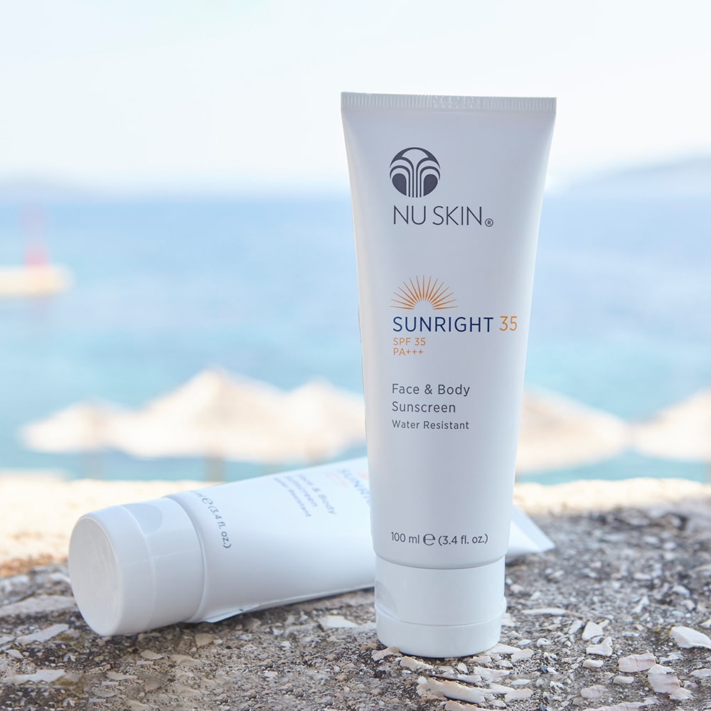 Sunright SPF 35/50 Tuben (je 100ml) nebeneinander auf leichter Felserhöhung vor Strand.